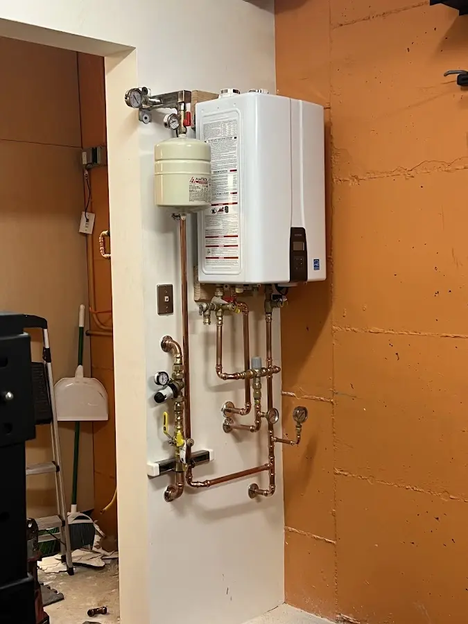 Plumbing technician inspecting water heater connections in Hernando